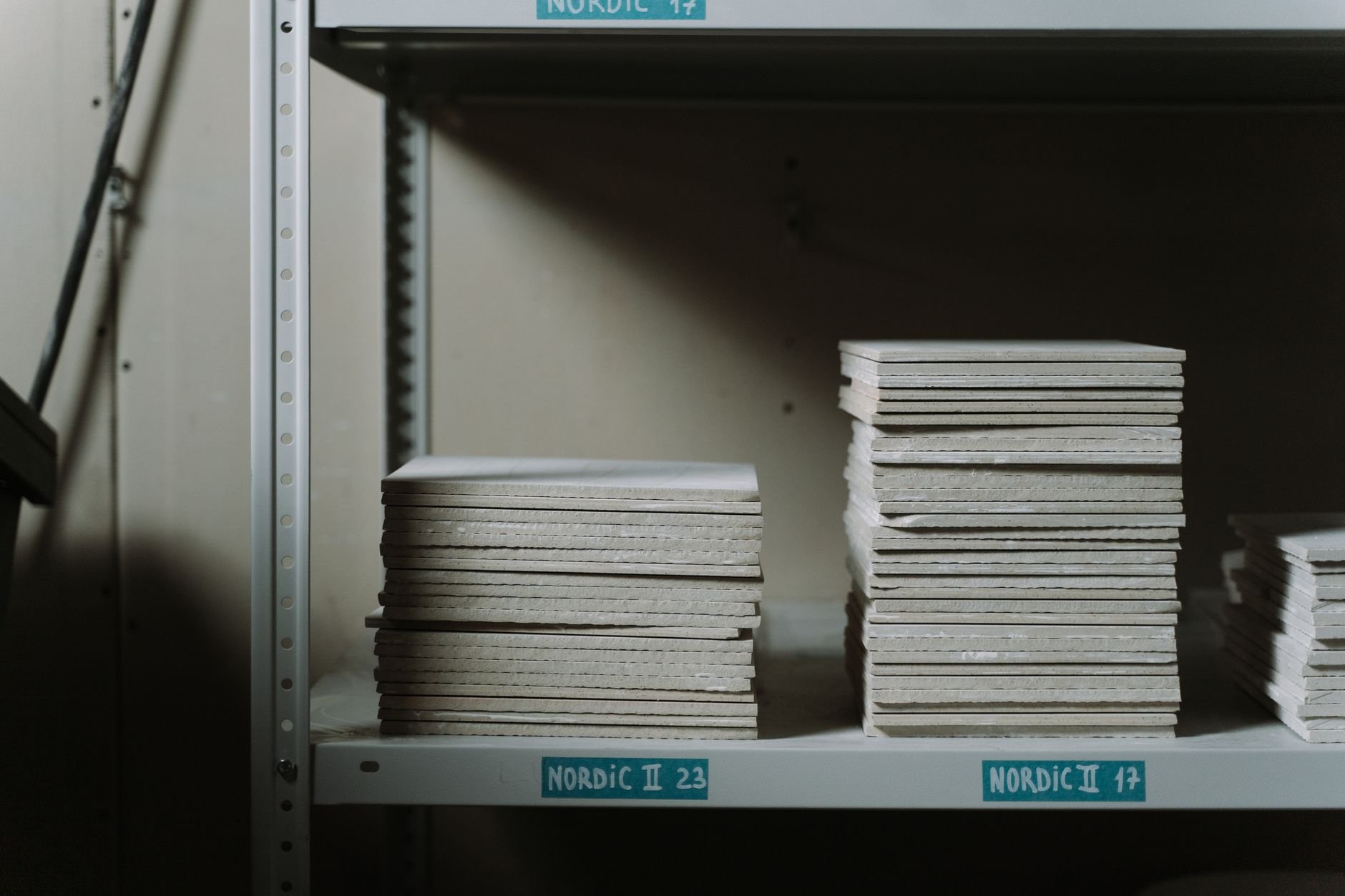 Stacks of ceramic tiles neatly arranged on industrial shelves in a warehouse